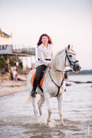 Фото девушки верхом на белом коне в воде