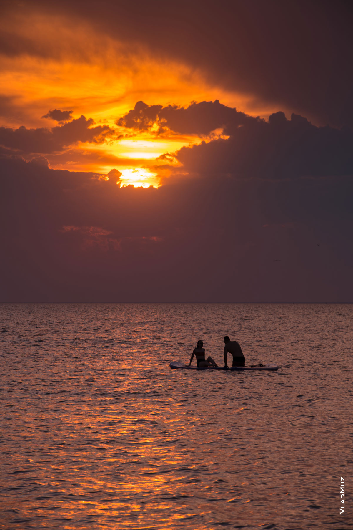 Морской закат. Летнее фото мужчины с девушкой на сапборде