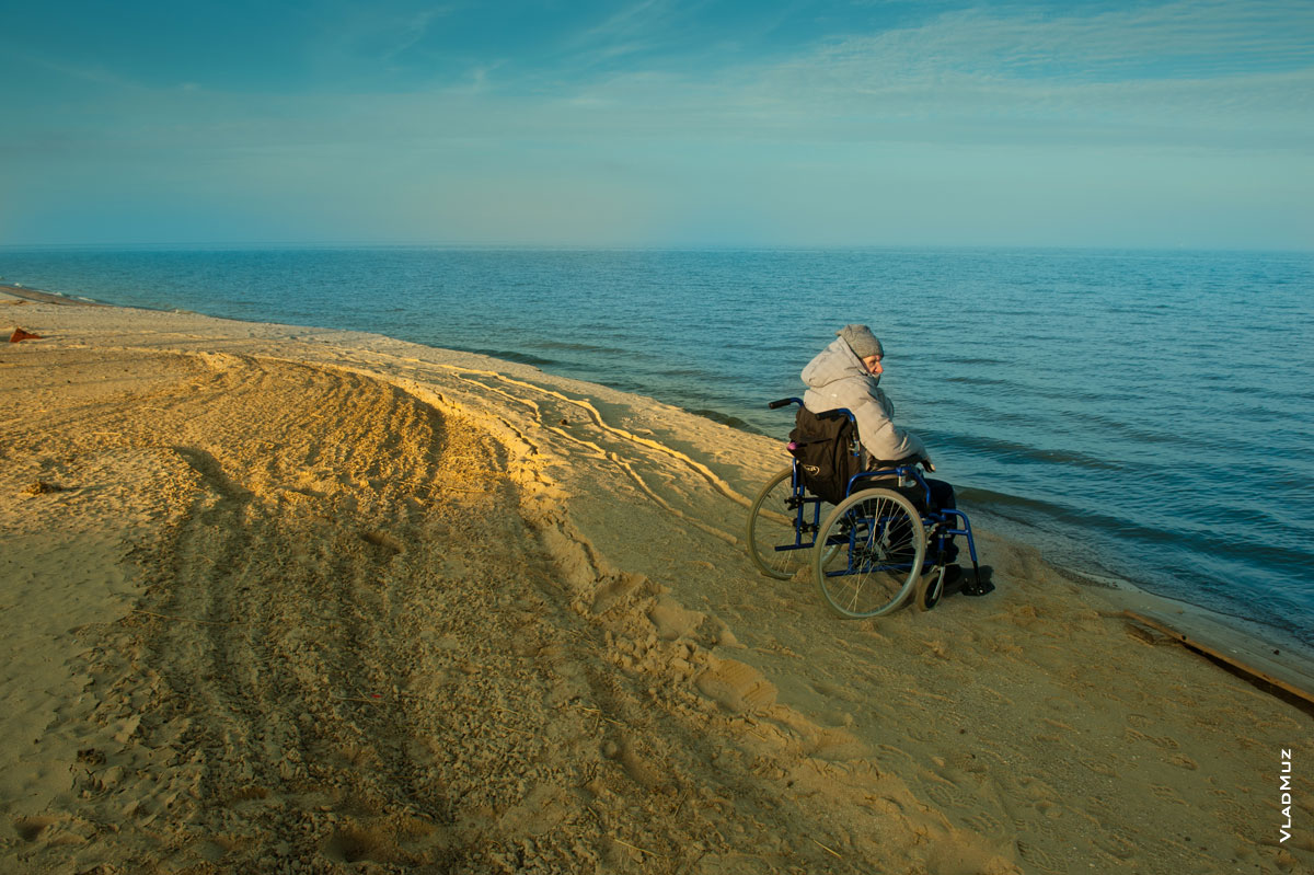 Фото мужчины в инвалидной коляске на пустынном морском берегу