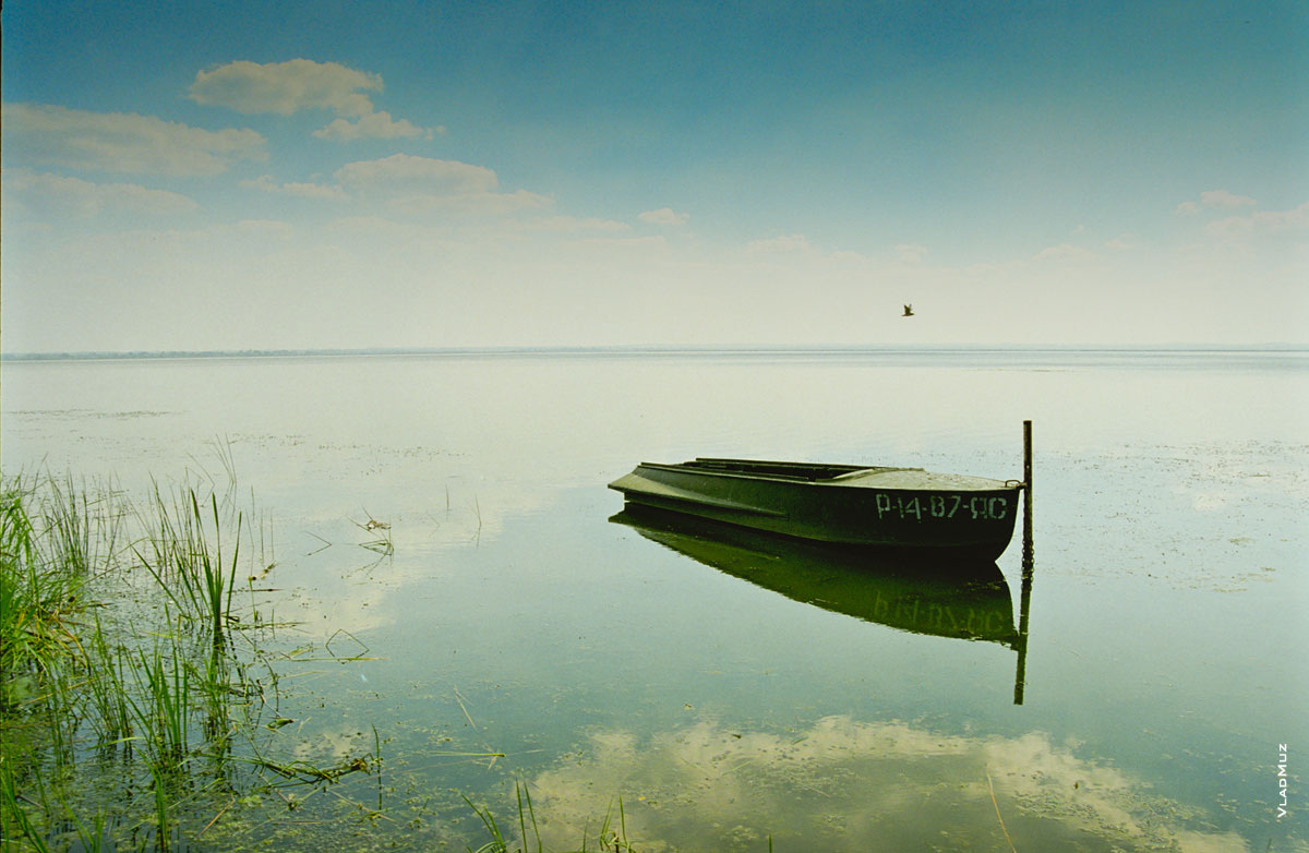 Фото пейзаж с лодкой на озере в штиль