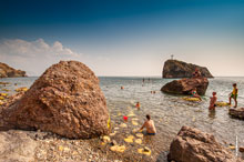 Фото камней на берегу Яшмового пляжа на Фиоленте и Георгиевской скалы вдали