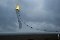 Красивая фотография факела Олимпийского огня «Сочи 2014» на фоне хмурого олимпийского неба