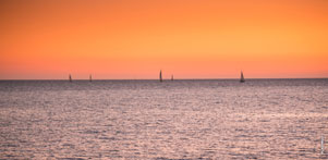 Морской фото пейзаж после заката солнца: яхты в море на горизонте
