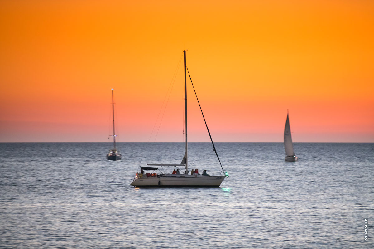 Фото яхты Arial с проводкой на фоне 2-х яхт. Фотопейзаж после заката солнца