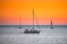 Фото яхты Arial с проводкой на фоне 2-х других яхт. Морской фотопейзаж после заката солнца