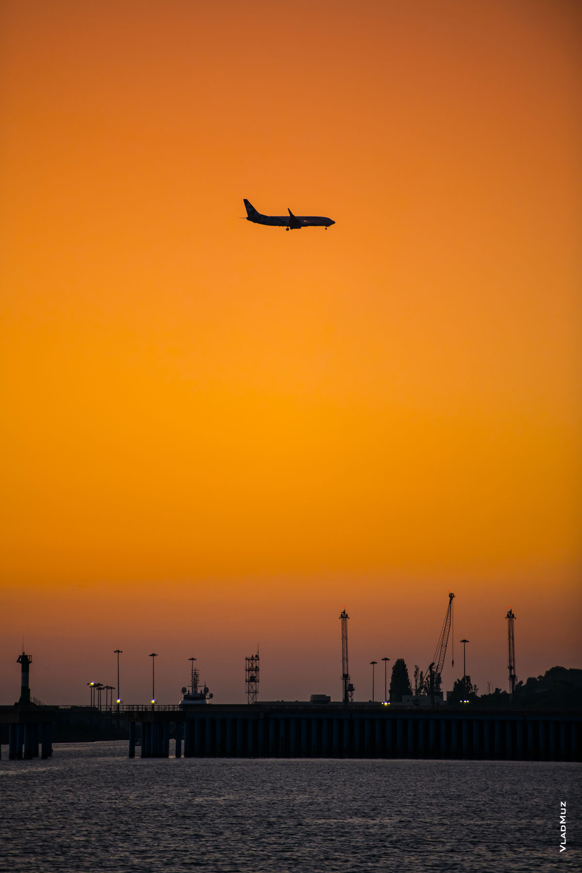 Фото самолета в небе на закате над Имеретинским морским портом в Адлере (Сочи)