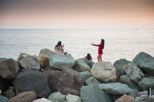 Фото девушек с телефонами на камнях набережной Имеретинского морского порта