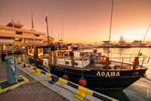 Фото сказочной моторной яхты «Лодиа» и волшебного капитана у 9-го причала Морпорта Сочи на закате солнца