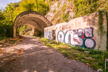 Фото граффити на бетонной стене и бетонной арочной галереи на заброшенной старой Краснополянской дороге в Сочи
