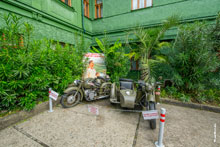 Фото 2-х тяжелых мотоциклов и советского плаката «Пусть здравствует и процветает наша Родина» во вдоре дачи Сталина