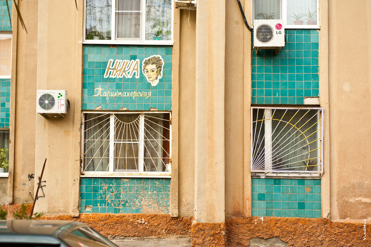 Городское фото Волгодонска: рисунок женского лица на кафельной плитке и надписи парикмахерской «Ника»