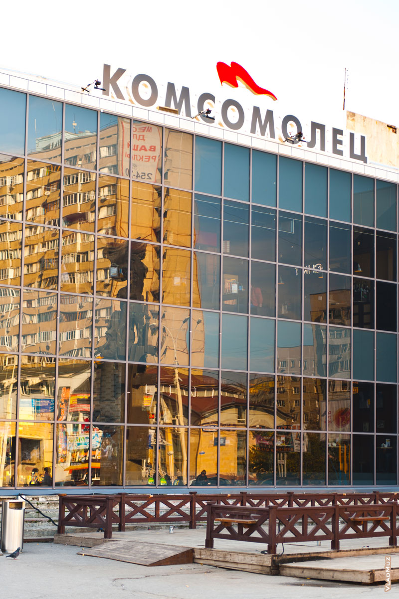 Фото памятника строителям Атоммаша и городских домов в кривом зеркале кинотеатра «Комсомолец»