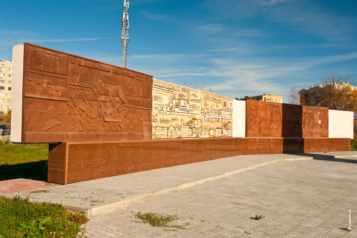 Фото плит с рельефной графикой строек Волгодонска рядом со стелой строителям