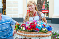 Туристы фотографируются рядом с нарядной цветочницей