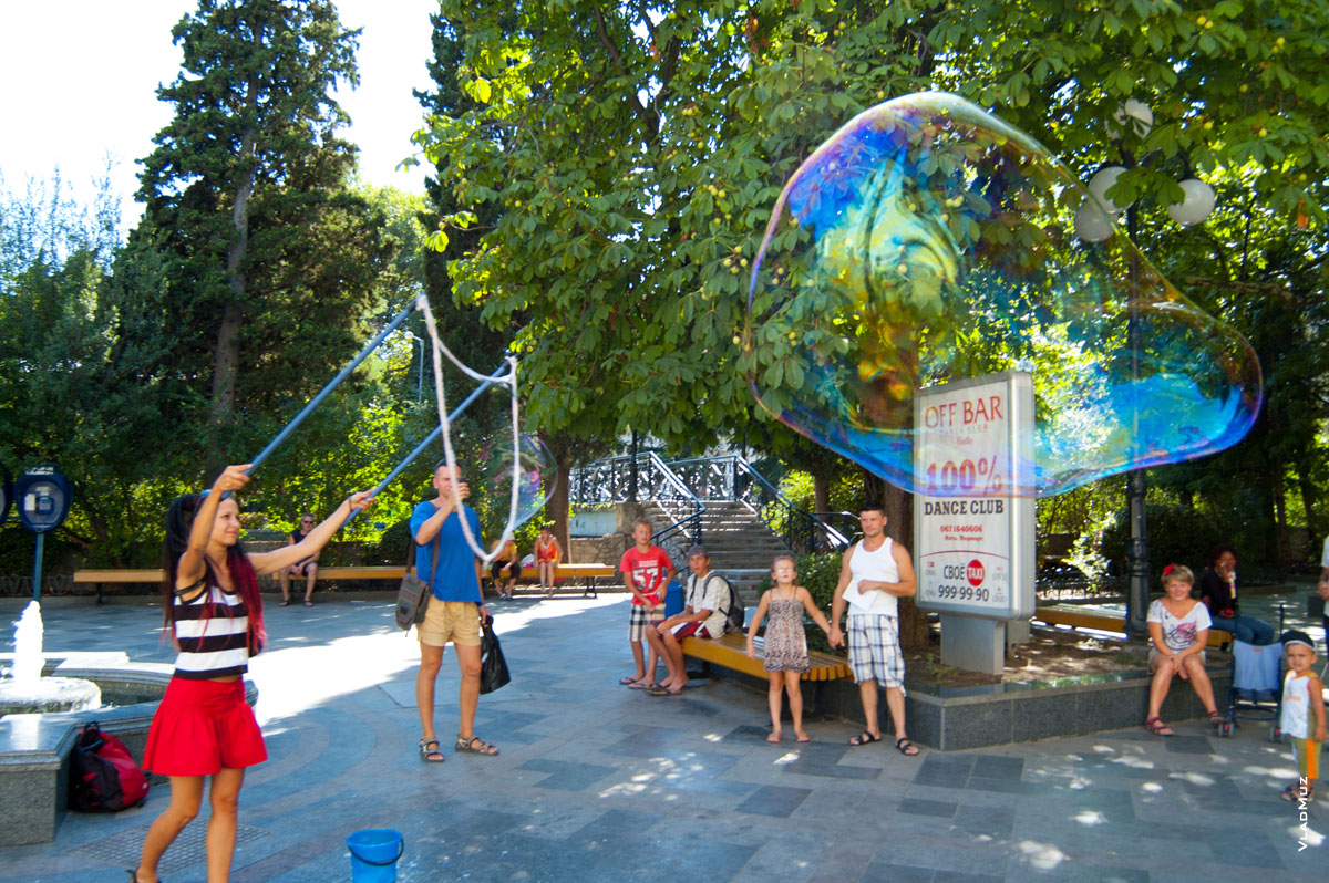 Фото в Ялте - девушка на улице Пушкинской пускает огромные мыльные пузыри